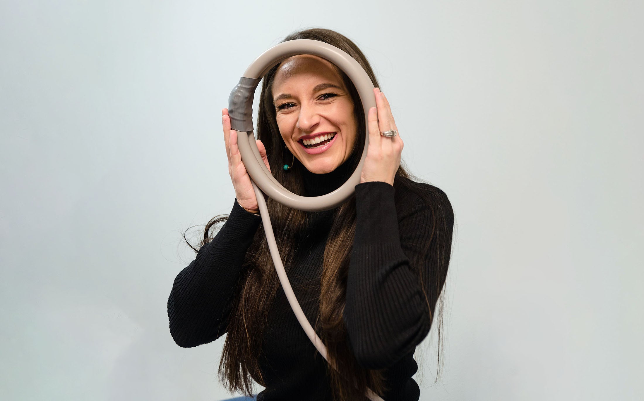 Woman smiling through PEMF loop held up to face